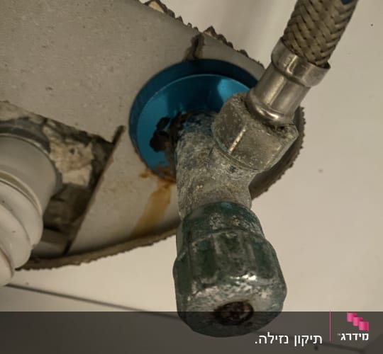 צינור מתכת מחובר לשסתום עם חלודה